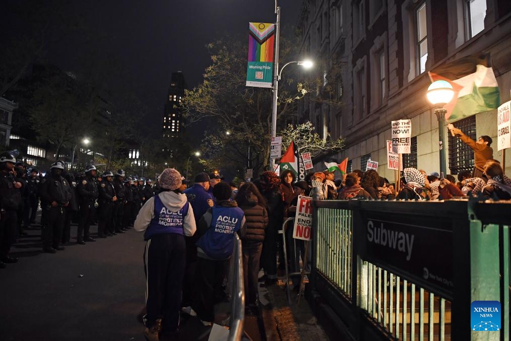 People participate in a pro-Palestinian demonstration as police officers stand guard outside Columbia University in New York, the United States, on April 24, 2024. Columbia University, amidst an eighth day of tense demonstrations, said on Wednesday that it has extended negotiations with student activists regarding the dismantling of a pro-Palestinian encampment.(Photo: Xinhua)