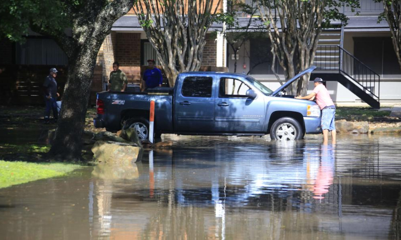 A man checks the car in a residential area in Spring, Texas, the United States, on May 2, 2024. Multiple rounds of thunderstorms are worsening flooding threats on Thursday across eastern Texas, including the Houston area, forcing evacuations and school closures. (Photo by Chengyue Lao/Xinhua)