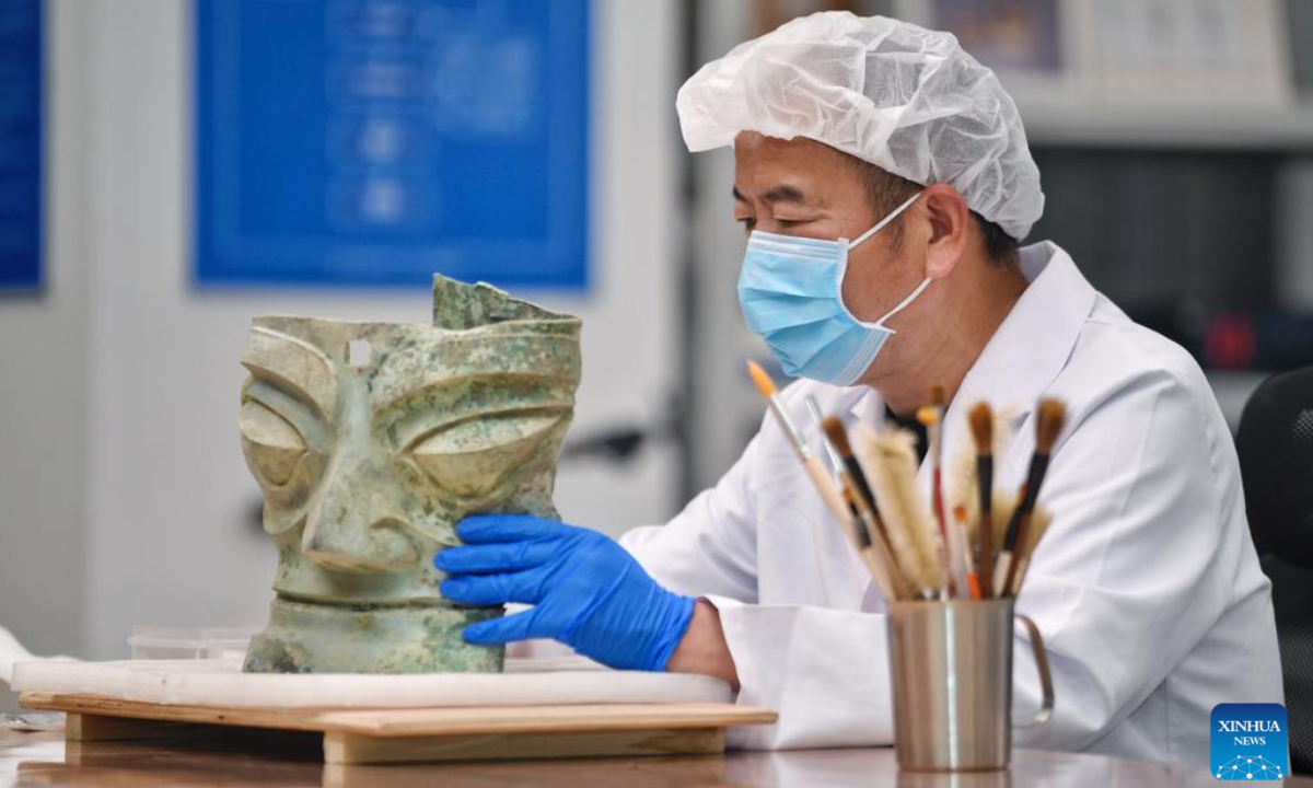 Guo Hanzhong cleans a bronze mask at Sanxingdui Museum in Guanghan City, southwest China's Sichuan Province, April 25, 2024. Photo:Xinhua