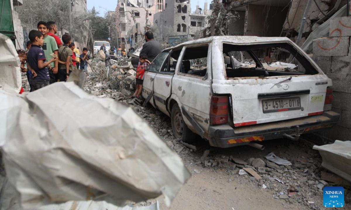 People gather near a destroyed vehicle in central Gaza Strip city of Deir el-Balah, on May 1, 2024. Photo:Xinhua