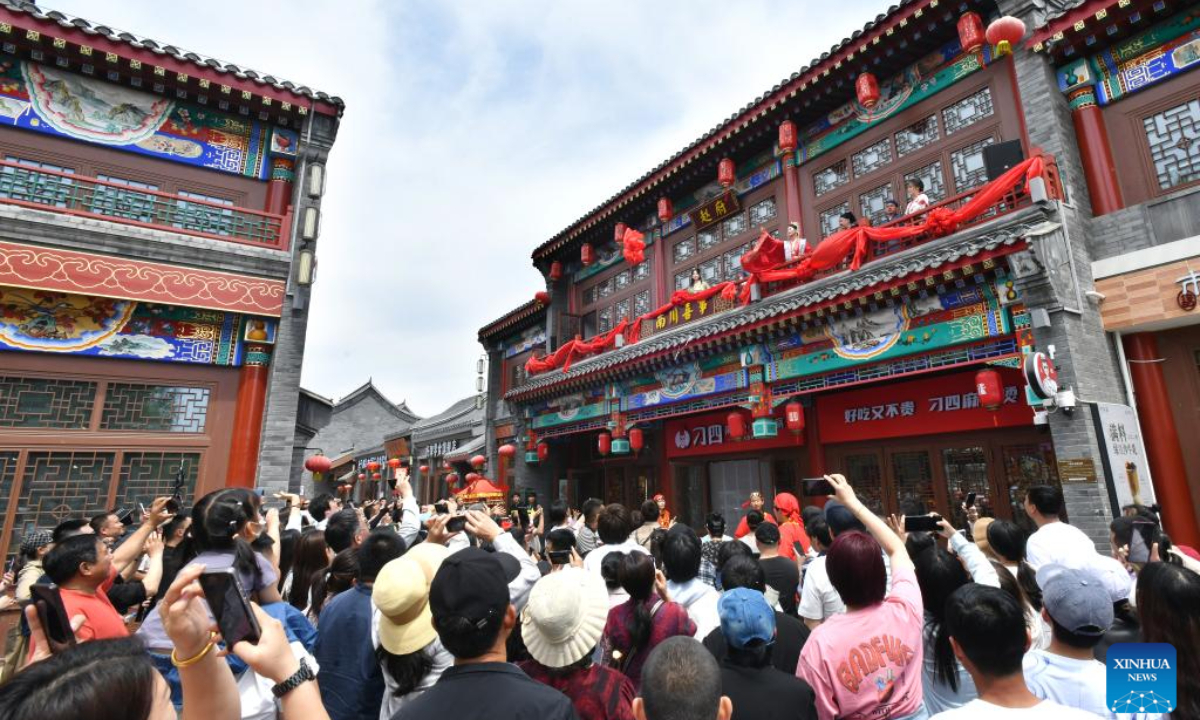 Tourists watch a folk performance at Nanchuan ancient street in Cangzhou, north China's Hebei Province, May 1, 2024. Photo:Xinhua