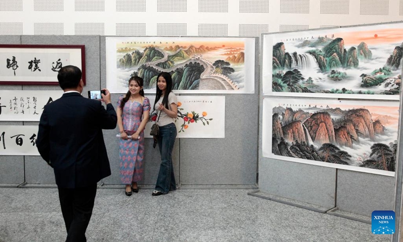 People pose for photos at a Cambodia-China paintings exhibition in Phnom Penh, Cambodia on April 26, 2024. A Cambodia-China paintings exhibition opened in Phnom Penh, capital of Cambodia, on Friday, attracting scores of visitors. Jointly organized by the Royal Academy of Cambodia and China's Jiujiang University, the half-day event displayed dozens of paintings featuring scenery, culture and tradition of both countries as well as Chinese calligraphy. (Photo: Xinhua)