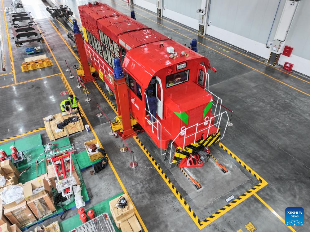 A drone photo taken on April 26, 2024 shows a locomotive to be remoulded into one powered by new energy at a workshop of Zhuzhou Lince Group Co., Ltd. in Zhuzhou, central China's Hunan Province. The rail transit equipment manufacturer has been ramping up production to meet orders from home and abroad. The company said its sales revenue grew by 68.96 percent year-on-year in the first quarter of 2024, with overseas orders soaring by 145 percent.(Photo: Xinhua)
