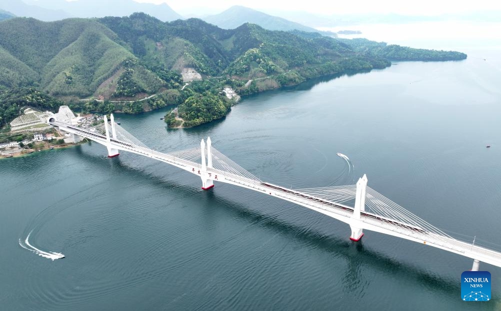 An aerial drone photo shows trains running on the Taipinghu grand bridge along the Chizhou-Huangshan Railway in east China's Anhui Province, April 26, 2024. Chizhou-Huangshan Railway, linking Chizhou City and Huangshan City of east China's Anhui Province, started operation on Friday. It is a tourism route connecting Jiuhua Mountain, Huangshan Mountain, Taiping Lake and other tourist attractions, which is of great significance for promoting the economic and social development along the route.(Photo: Xinhua)