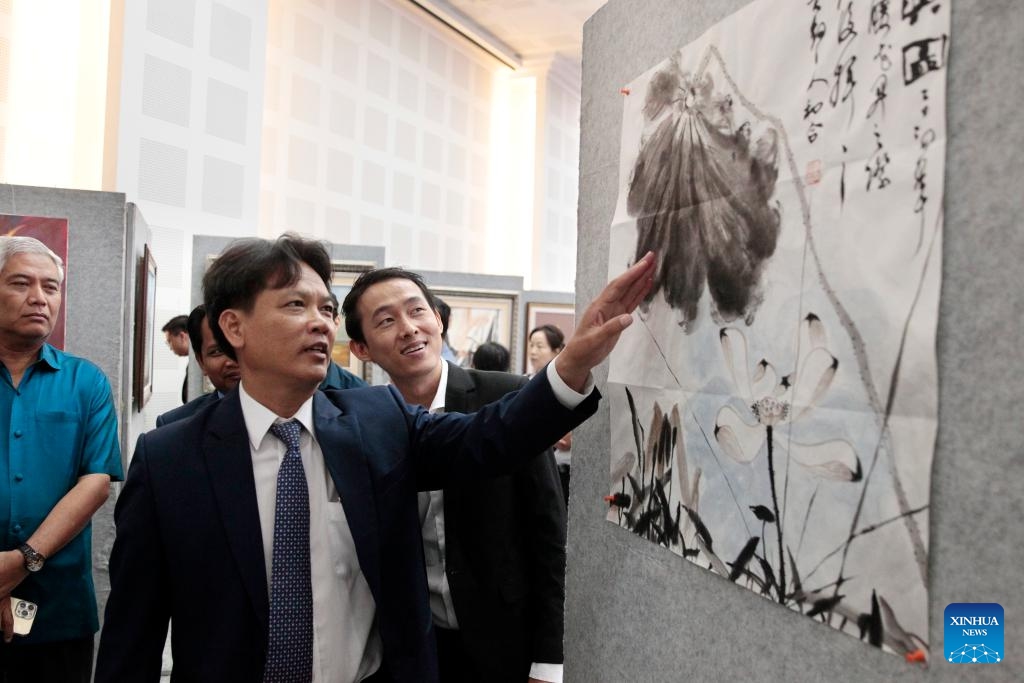Sok Touch (2nd R), president of the Royal Academy of Cambodia, looks at a Chinese painting at a Cambodia-China paintings exhibition in Phnom Penh, Cambodia on April 26, 2024. A Cambodia-China paintings exhibition opened in Phnom Penh, capital of Cambodia, on Friday, attracting scores of visitors.(Photo: Xinhua)