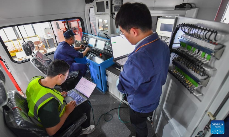 Staff members check the operation of a new engergy locomotive at a workshop of Zhuzhou Lince Group Co., Ltd. in Zhuzhou, central China's Hunan Province, April 26, 2024. The rail transit equipment manufacturer has been ramping up production to meet orders from home and abroad. The company said its sales revenue grew by 68.96 percent year-on-year in the first quarter of 2024, with overseas orders soaring by 145 percent.(Photo: Xinhua)