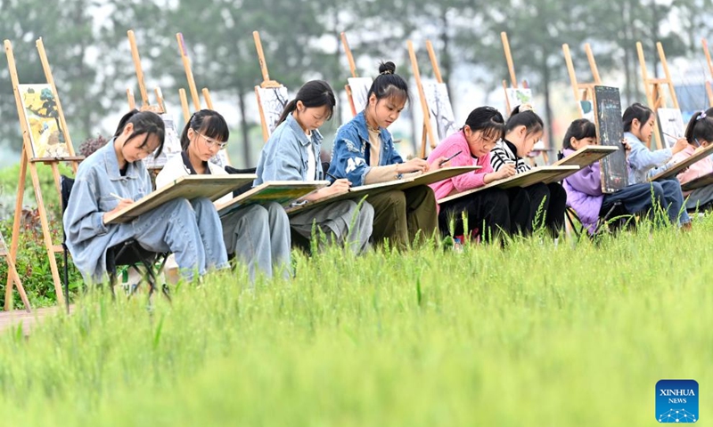 Children work on paintings by a field in Yuxin Town of Nanhu District, Jiaxing City, east China's Zhejiang Province, April 27, 2024. Photo: Xinhua
