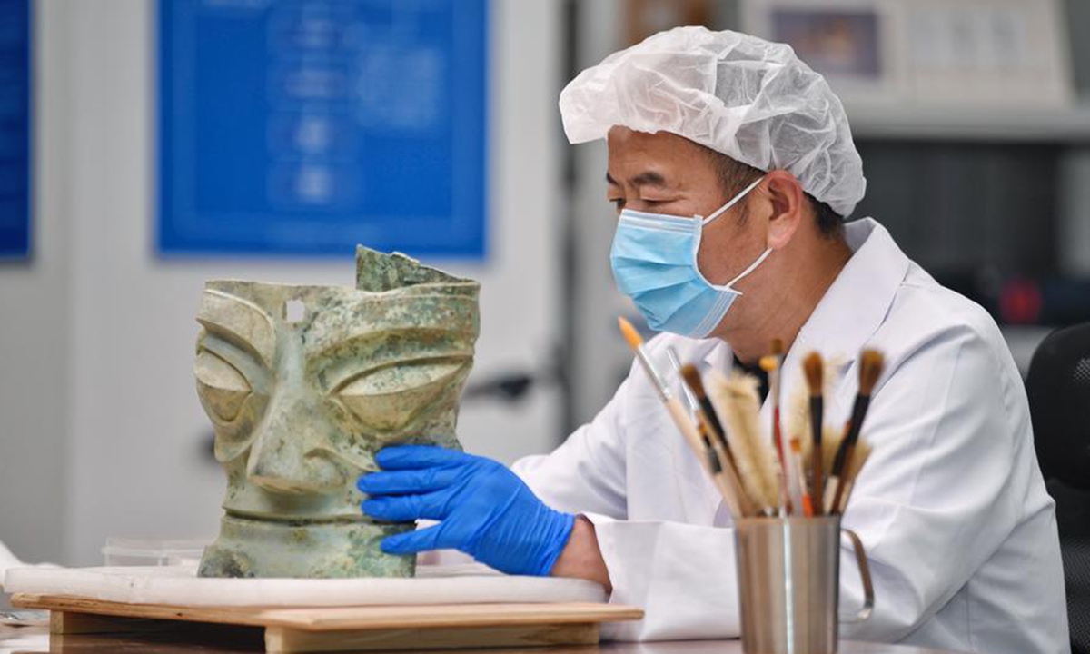 Guo Hanzhong cleans a bronze mask at Sanxingdui Museum in Guanghan City, southwest China's Sichuan Province, April 25, 2024. (Xinhua/Liu Kun)