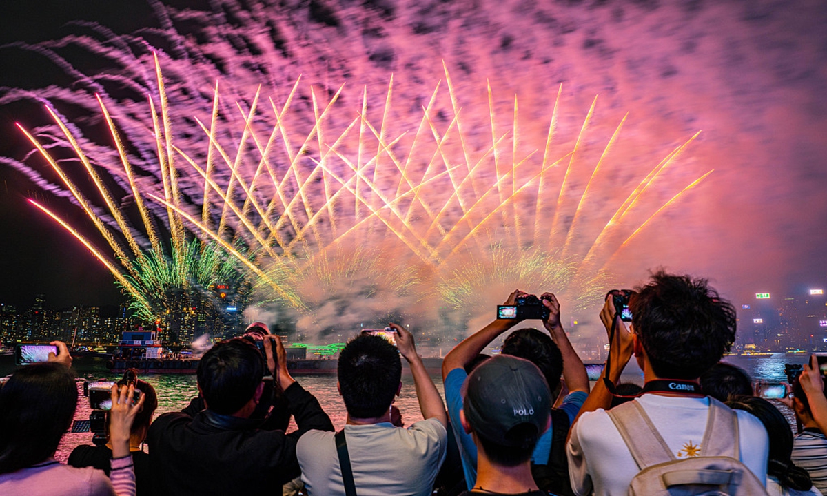 Visitors enjoy the fireworks that lights up the night sky over Victoria Harbour in Hong Kong on May 1，2024. Photo: VCG