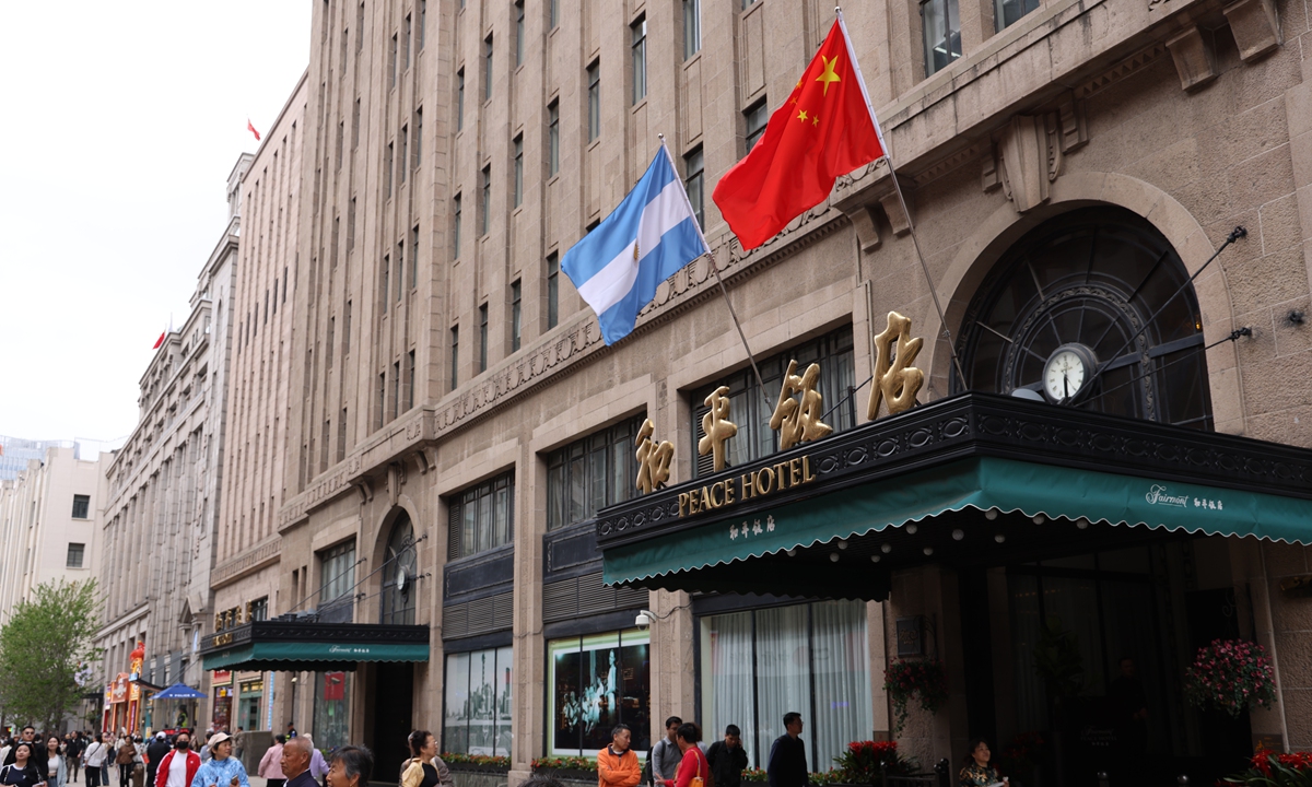 Pedestrians walk past the Peace Hotel in Shanghai as the national flags of China and Argentina were hoisted on April 27, 2024. Photo: VCG