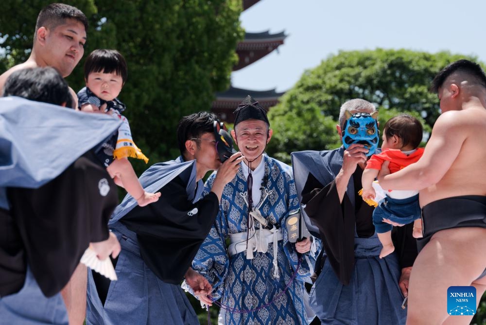 Sumo wrestlers hold children during the Naki Sumo Crying Baby Contest in Tokyo, Japan, on April 28, 2024. Naki Sumo is a traditional ceremony performed as a prayer for healthy growth.(Photo: Xinhua)