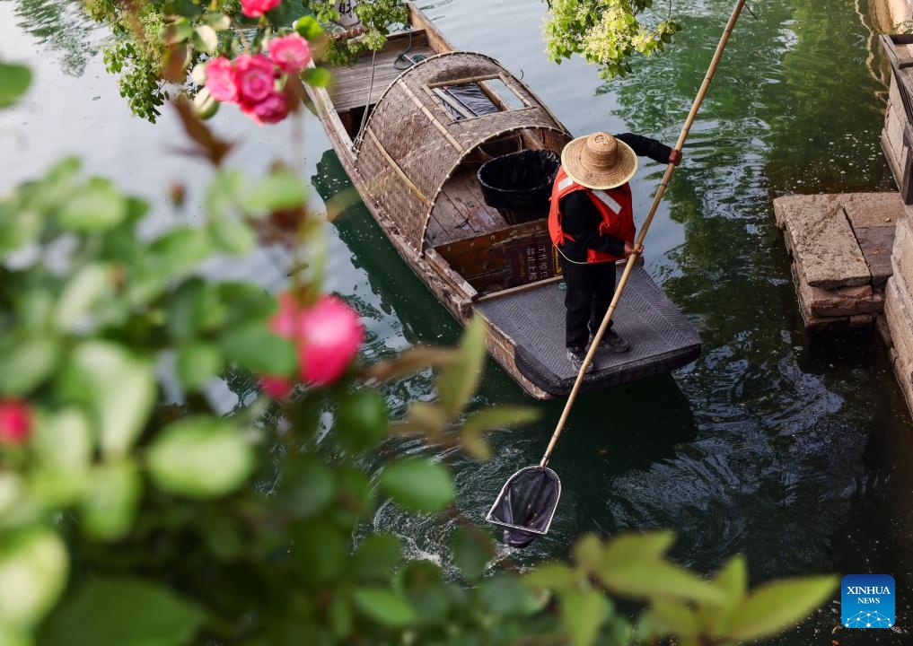 A staff member removes garbage from water at the Puyuan Fashion Resort in Jiaxing of east China's Zhejiang Province, April 26, 2024. Paying tribute to the elegant aesthetics of the Song Dynasty (960-1279), the heyday of ancient Chinese art, while combing modern elements, the Puyuan Fashion Resort in Jiaxing of east China's Zhejiang Province offers an immersive cultural travel experience to visitors, ranging from Hanfu fashion shows to themed markets, concerts and sports games.(Photo: Xinhua)