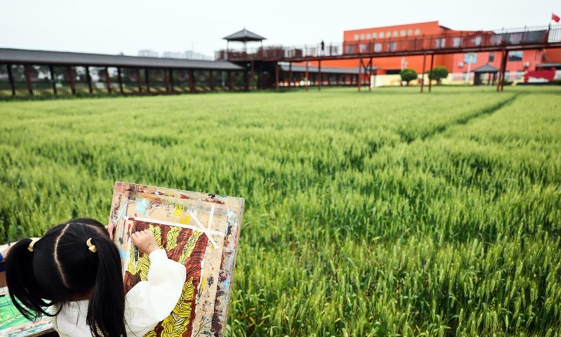 A child draws a picture in the fields at Yuxin Town of Nanhu District in Jiaxing City, east China's Zhejiang Province, April 27, 2024. As a demonstration zone for harmonious and beautiful village, the Nanhu District has developed industries including study tour, village-level exhibition, and outdoor activity with joint efforts of local authorities, enterprises, collectives, and farmers to increase incomes and boost rural revitalization. (Xinhua/Lan Hongguang)