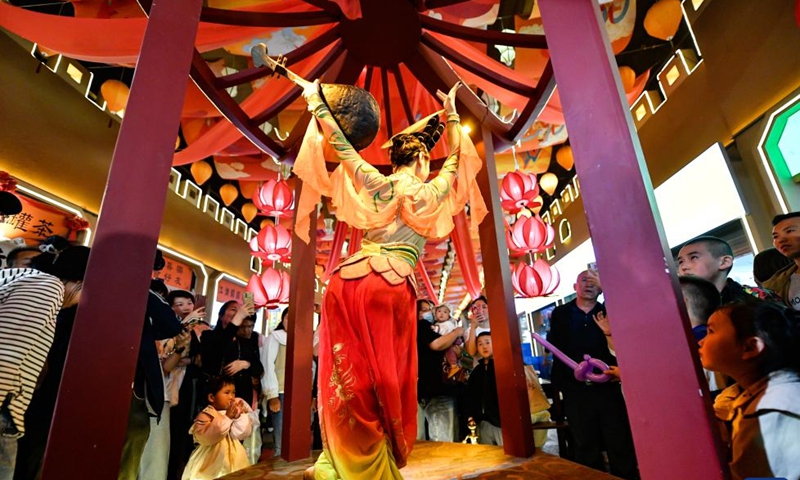 Tourists watch a performance at a gourmet street of Chengguan District in Lanzhou, capital of northwest China's Gansu Province, April 26, 2024. As the May Day holiday is approaching, Lanzhou has continued to promote the development of night economy, releasing new vitality for consumption. (Xinhua/Lang Bingbing)