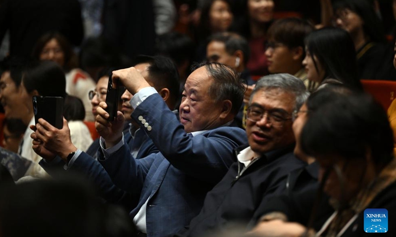 Mo Yan takes photos of the stage before the debut of his new drama Crocodile at a theater in Suzhou, east China's Jiangsu Province, May 3, 2024. Crocodile, a new drama by Mo Yan, a winner of Nobel Prize for Literature, made its debut here on Friday. (Xinhua/Jin Liangkuai)
