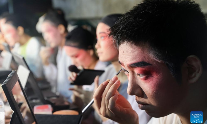 Chen Kehan (1st R) puts on makeup before performance at Lingmei Village in Haikou, south China's Hainan Province, May 2, 2024. Qiong Opera could be traced back to a century ago in Dingan County in this southern Chinese island, which is referred to as Qiong in abbreviation.(Xinhua/Zhang Liyun)