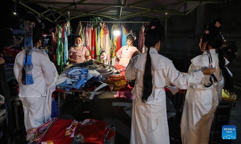 Actors of the Dingan County Qiong Opera Troupe change their costumes at the back of the stage during a performance in Dingan County, south China's Hainan Province, April 23, 2024. Qiong Opera could be traced back to a century ago in Dingan County in this southern Chinese island, which is referred to as Qiong in abbreviation.(Xinhua/Zhang Liyun)