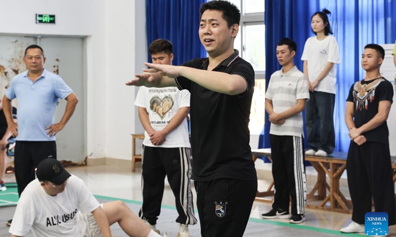 Chen Kehan (C front) and his colleagues rehearse as his father Chen Liubo (1st L) looks on in Dingan County, south China's Hainan Province, April 24, 2024. Qiong Opera could be traced back to a century ago in Dingan County in this southern Chinese island, which is referred to as Qiong in abbreviation.(Xinhua/Zhang Liyun)