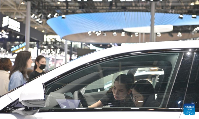 A visitor (R) study a new energy vehicle during the 2024 Beijing International Automotive Exhibition in Beijing, capital of China, May 4, 2024. The exhibition closed on Saturday. Photo: Xinhua