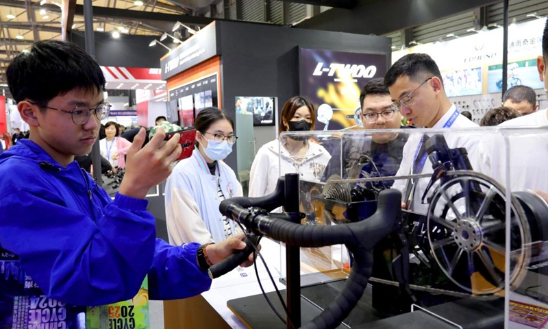 A visitor takes photos of an exhibit during the 32nd China International Bicycle Fair in east China's Shanghai, May 5, 2024. The event kicked off here on Sunday, drawing about 1,460 enterprises to participate. Photo: Xinhua