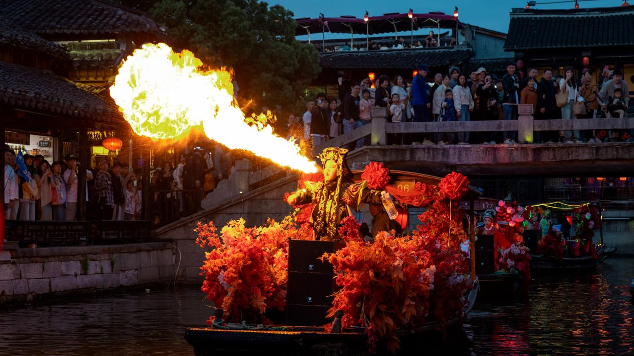 The crowd watched the fire-breathing performance, which showed their inheritance and love for traditional culture.