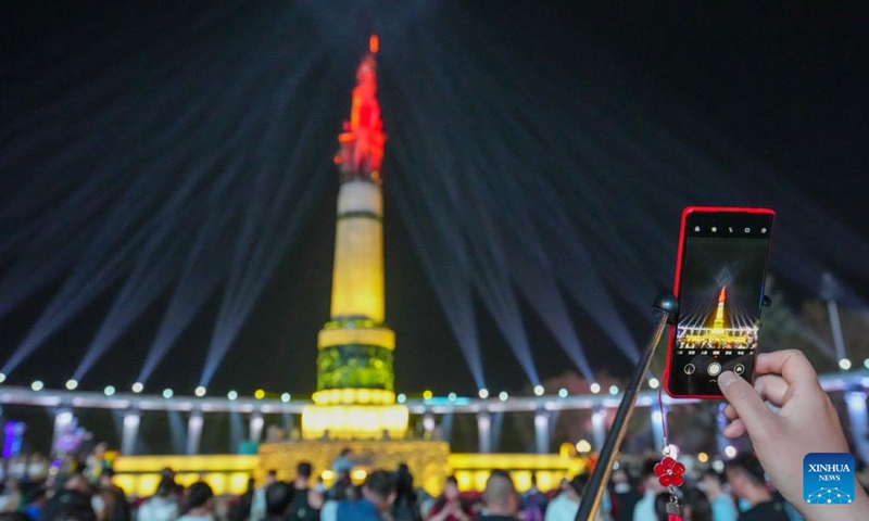 A visitor takes photos of a light show held at a square in Harbin, capital of northeast China's Heilongjiang Province, May 3, 2024. Photo: Xinhua