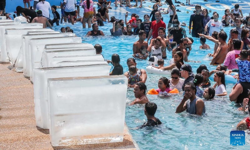People wait for ice blocks to be put into a swimming pool at a resort in Bulacan Province, the Philippines, on May 5, 2024. People spend time at pools to cool off amid heatwave in the Philippines. Photo: Xinhua