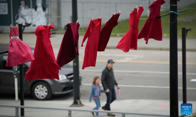 Red dresses are hung along a street to mark the National Day of Awareness for Missing and Murdered Indigenous Women and Girls in New Westminster, British Columbia, Canada, on May 5, 2024. May 5 is the National Day of Awareness for Missing and Murdered Indigenous Women and Girls, also known as Red Dress Day, in Canada. Photo: Xinhua