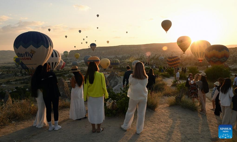 People watch hot air balloons flying over Cappadocia in Nevsehir, Türkiye on May 5, 2024. (Mustafa Kaya/Handout via Xinhua)
