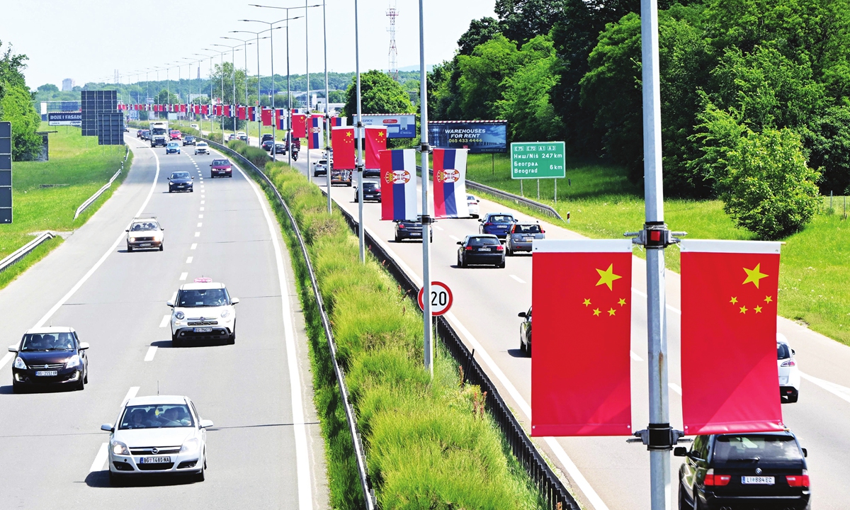 Motorists drive past Serbian and Chinese flags along the high-way leading into Belgrade, Serbia, on May 6, 2024. Photo: VCG