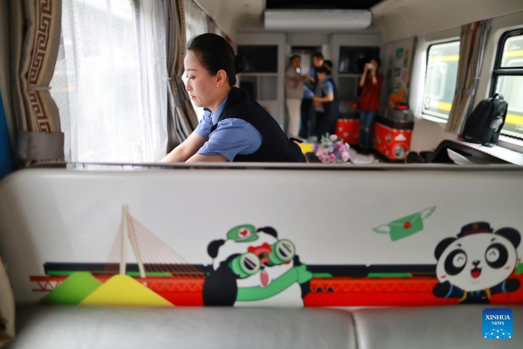 Train attendants prepare a Panda Train in Guiyang, capital of southwest China's Guizhou Province, May 7, 2024. A tourist train, decorated with images, paintings and mascots of the panda and named as Panda Train, linking Guiyang, Xishuangbanna and Laos, will depart from Guiyang on May 8.(Photo: Xinhua)