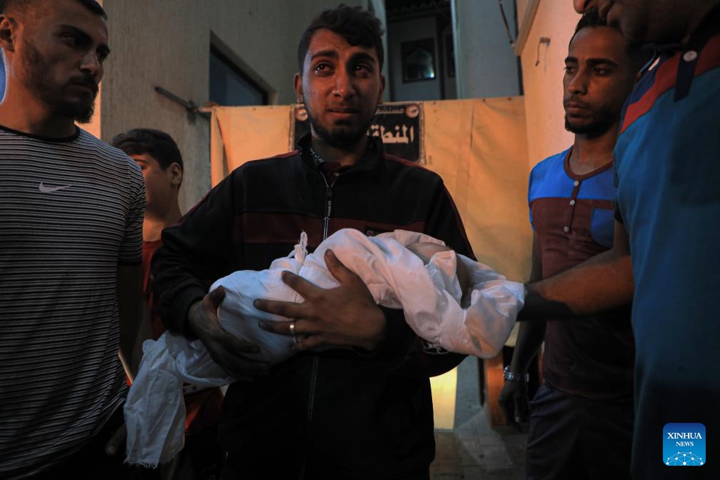 A man holds the body of a child killed in an Israeli airstrike at a hospital in the southern Gaza Strip city of Rafah, on May 7, 2024.(Photo: Xinhua)