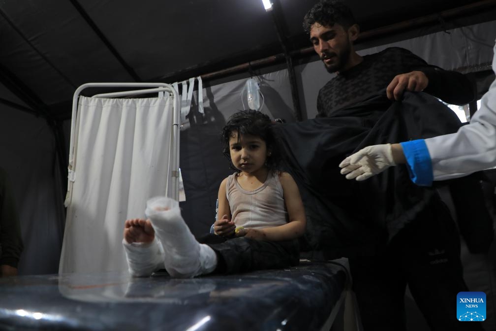 An injured girl is treated at a temporary clinic in the southern Gaza Strip city of Rafah, on May 8, 2024. Israel's army announced on Wednesday that it was continuing its ground assault on Gaza's Rafah, reporting approximately 30 casualties since the offensive began on Monday night. According to an army statement, the 30 casualties were militants, while Gaza health officials reported about 35 deaths, including a four-month-old baby.(Photo: Xinhua)