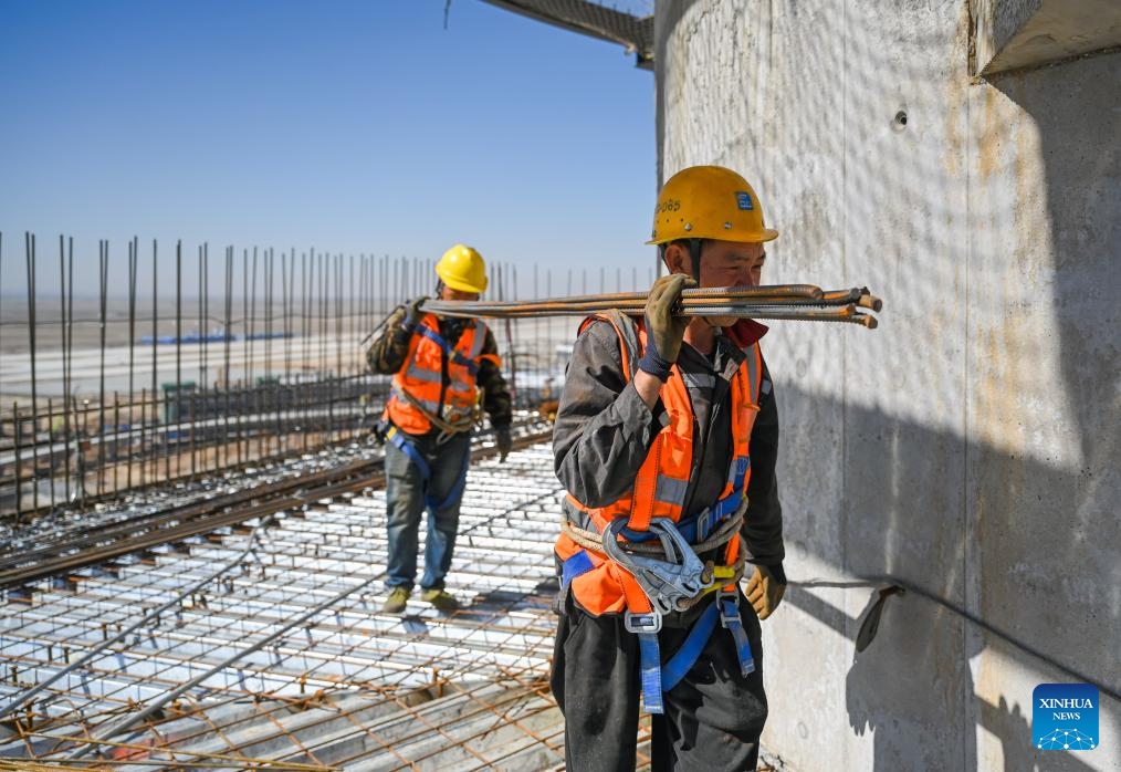 Workers carry construction materials at the construction site of an air traffic control tower in Hohhot, north China's Inner Mongolia Autonomous Region, May 8, 2024. The capping of the main structure of an air traffic control tower of a new airport in Hohhot has been completed on Wednesday.(Photo: Xinhua)