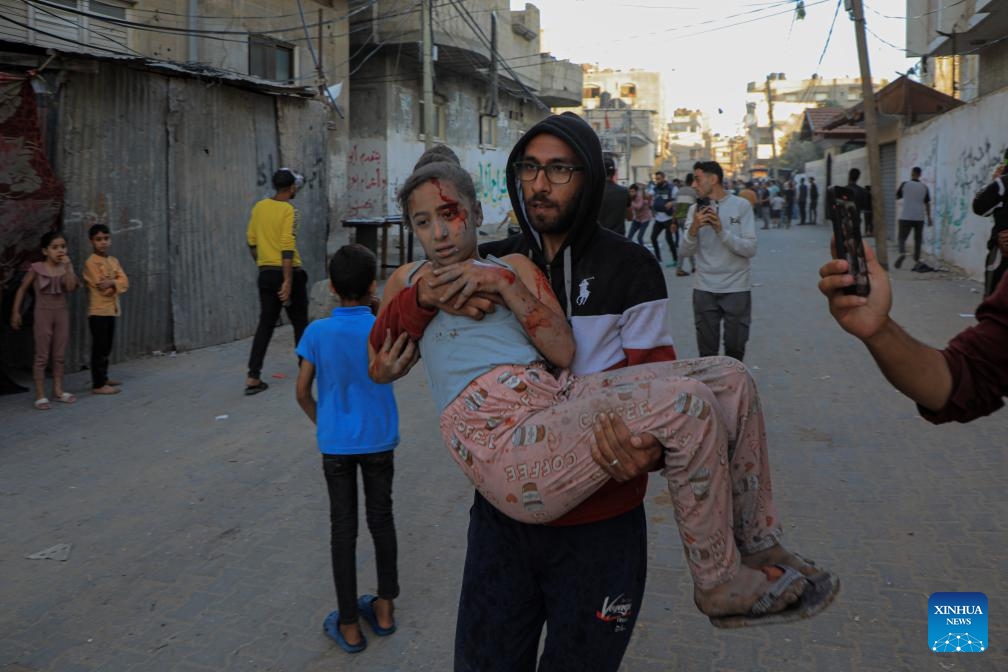 A man carries an injured girl on a street in the southern Gaza Strip city of Rafah, on May 8, 2024. Israel's army announced on Wednesday that it was continuing its ground assault on Gaza's Rafah, reporting approximately 30 casualties since the offensive began on Monday night. According to an army statement, the 30 casualties were militants, while Gaza health officials reported about 35 deaths, including a four-month-old baby.(Photo: Xinhua)