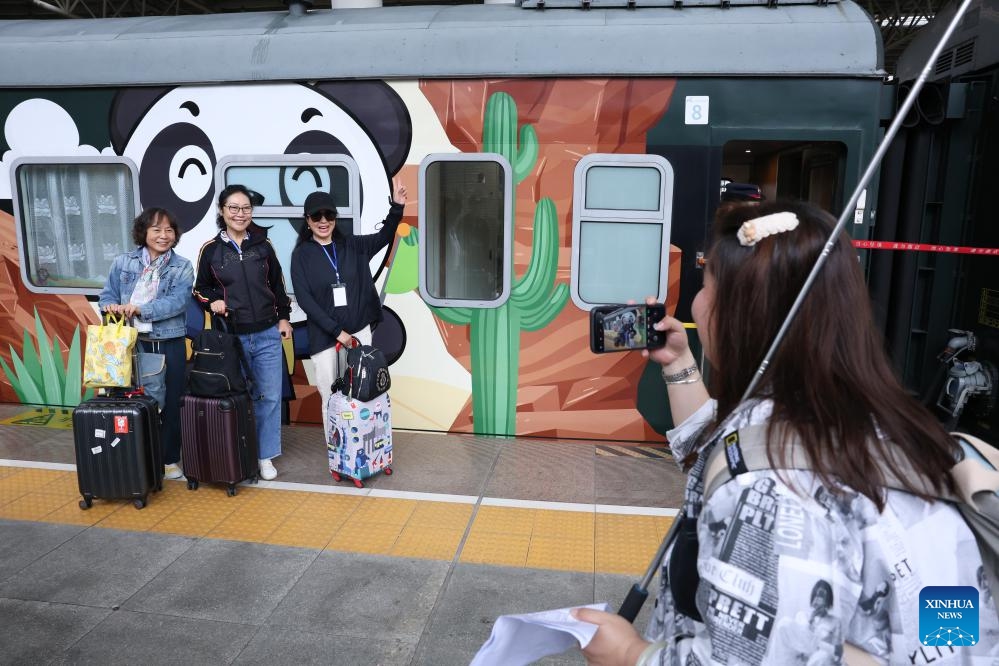 Passengers pose for photos with a Panda Train at Guiyang railway station in Guiyang, capital of southwest China's Guizhou Province, May 8, 2024. A tourist train, decorated with images, paintings and mascots of the panda and named as Panda Train, linking Guiyang, Xishuangbanna and Laos, departed from Guiyang on Wednesday.(Photo: Xinhua)
