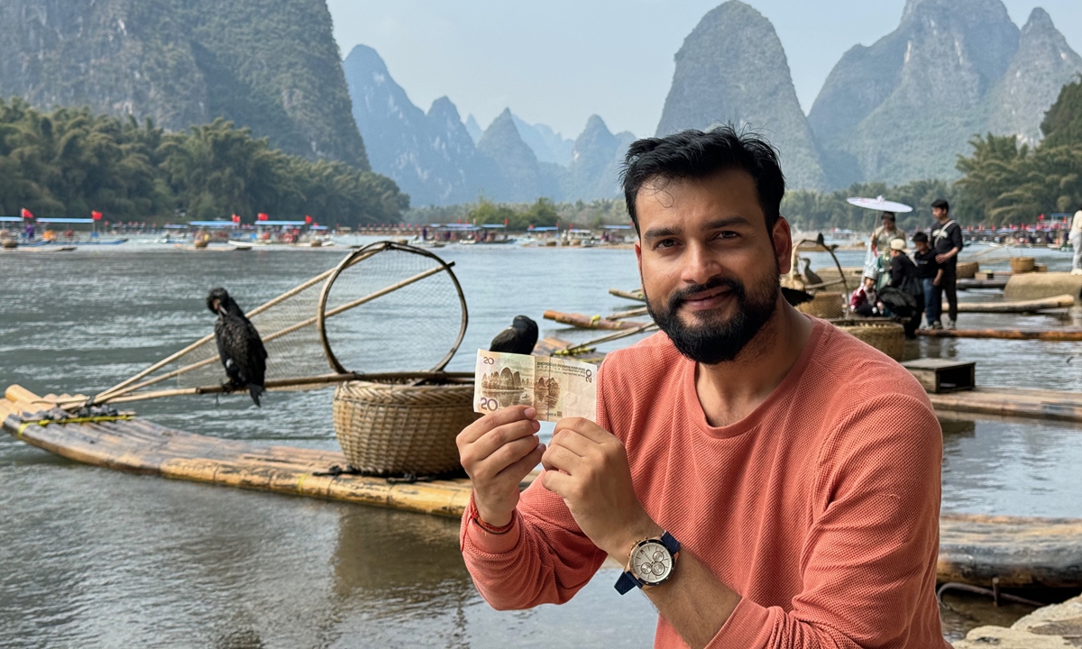 Indian travel vlogger Ansh Mishra poses with a 20-yuan Chinese banknote at Guilin, where the picture on the banknote comes from. Photo: Courtesy of Mishra