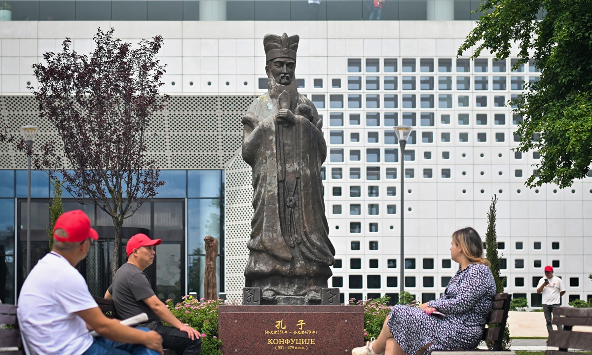 Visitors sit near a statue of Confucius in front of the Chinese Cultural Center in Belgrade, capital of Serbia, on May 7, 2024. Photo: VCG