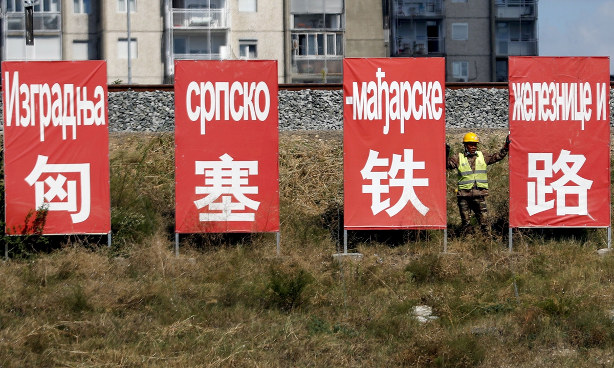 A worker rests between billboards that read 