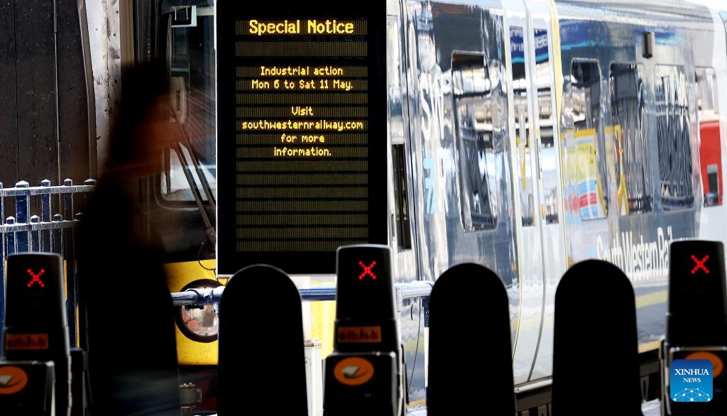 A passenger walks past a notice of industrial action at Waterloo Station in London, Britain, on May 8, 2024. Train drivers in Britain went on a fresh wave of strikes and overtime bans, disrupting rail travel this week.(Photo: Xinhua)