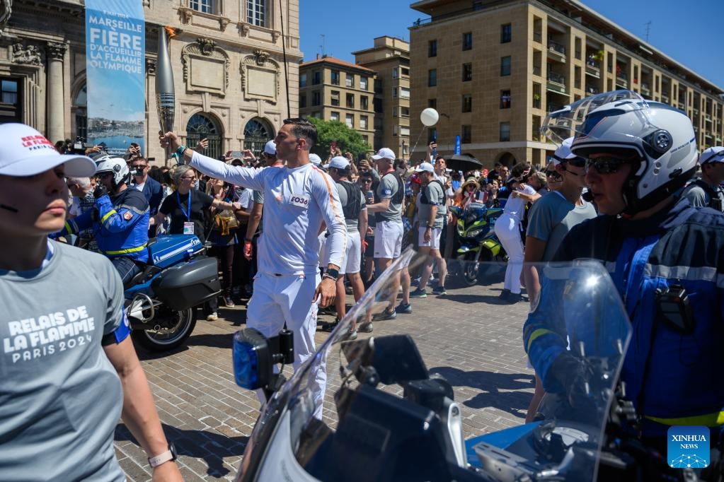 Local firefighter and torch bearer Matthieu Gudet holds the Olympic Torch during the relay of the Olympic flame of Paris 2024 in Marseille, France, May 9, 2024.(Photo: Xinhua)