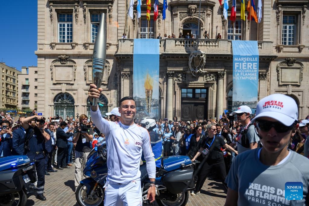 Local firefighter and torch bearer Matthieu Gudet holds the Olympic Torch during the relay of the Olympic flame of Paris 2024 in Marseille, France, May 9, 2024.(Photo: Xinhua)