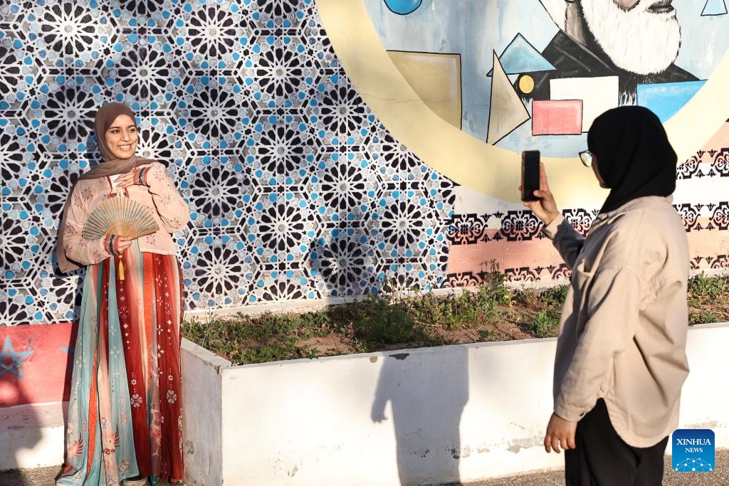 A woman wearing Hanfu poses for photos at the 20th world culture festival in Rabat, Morocco, May 8, 2024. The 20th world culture festival of the Rabat School of Mines kicked off here on Wednesday. Chinese paper-cutting, Lu Ban Lock and painting of opera facial mask were welcomed by Moroccan students.(Photo: Xinhua)