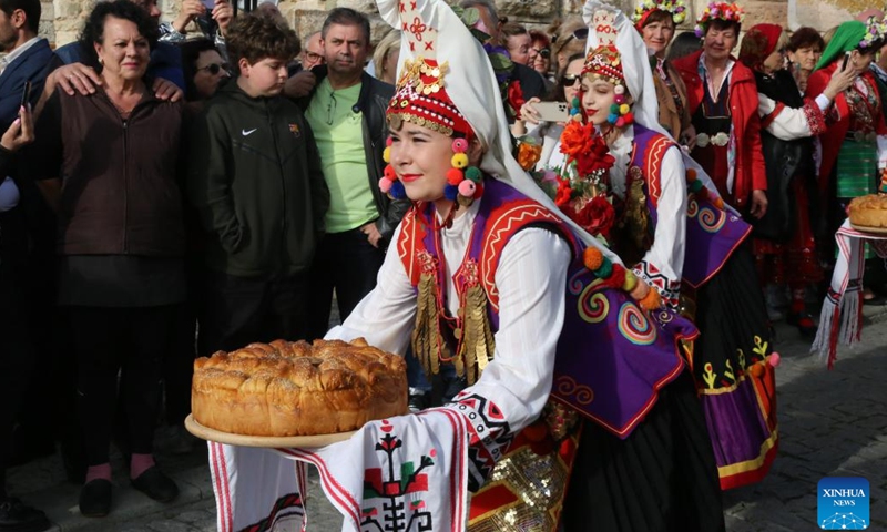 Girls in folk costumes present bread at the opening event of Bulgaria's summer tourism season in Nessebar, Bulgaria, on May 17, 2024. The summer tourist season in Bulgaria officially opened on Friday. (Xinhua/Lin Hao)