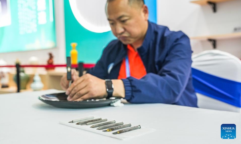 Chen Yinfu makes an artwork of Dafeng porcelain carving during a national vocational skills competition held in Guiyang, southwest China's Guizhou Province, May 8, 2024. Chen from Yancheng City of Jiangsu Province is an inheritor of Dafeng porcelain carving craftsmanship, which is a national-level intangible cultural heritage and allows artists to create dots and lines by cutting glaze with chisels on porcelain pieces. Photo: Xinhua
