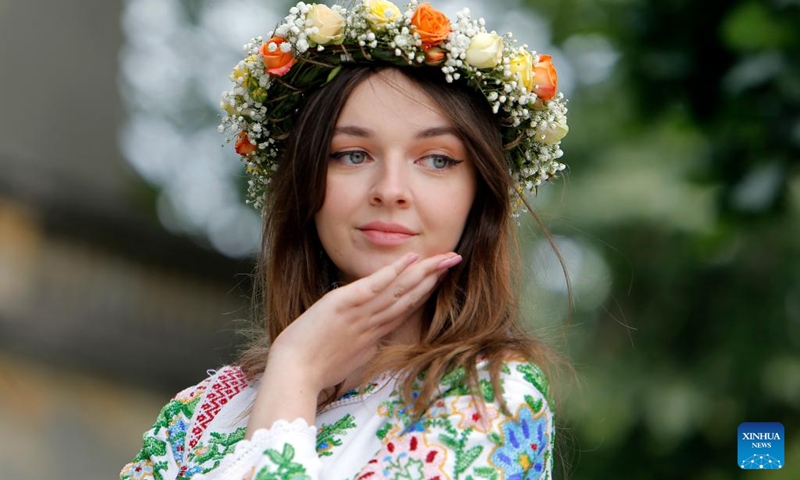 A woman wearing handmade traditional clothes poses during an event celebrating Romanian traditional costume in Bucharest, Romania, May 12, 2024. Photo: Xinhua