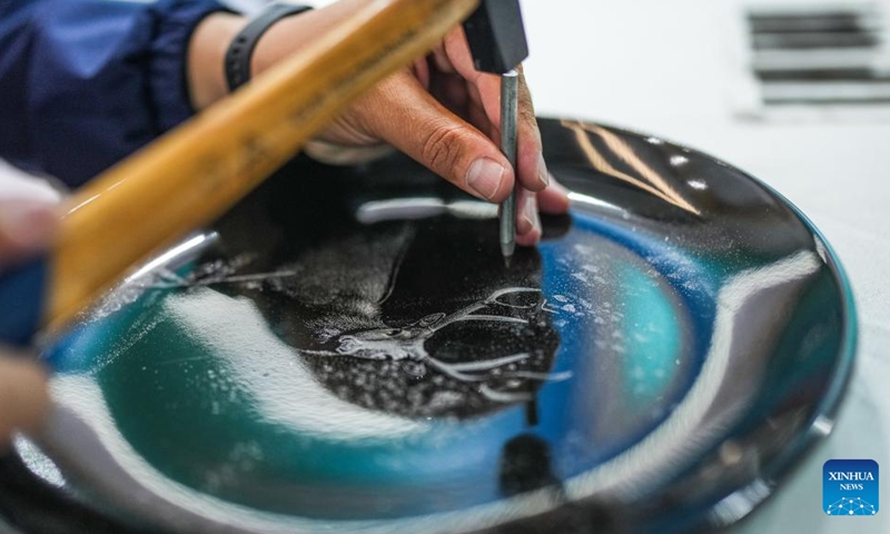 Chen Yinfu makes an artwork of Dafeng porcelain carving during a national vocational skills competition held in Guiyang, southwest China's Guizhou Province, May 8, 2024. Chen from Yancheng City of Jiangsu Province is an inheritor of Dafeng porcelain carving craftsmanship, which is a national-level intangible cultural heritage and allows artists to create dots and lines by cutting glaze with chisels on porcelain pieces. Photo: Xinhua