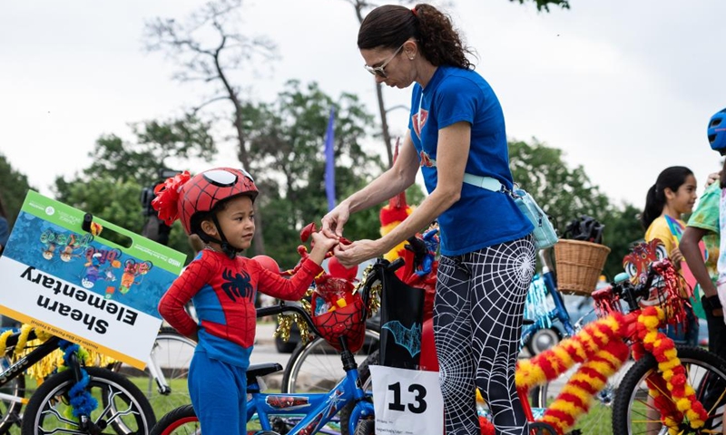 A child dressed in a Spider-man costume prepares during the 3rd Art Bike Parade & Festival in Houston, Texas, the United States, May 11, 2024. The annual event attracted hundreds of people to showcase their creativity in bike designing and enjoy various of activities. Photo: Xinhua