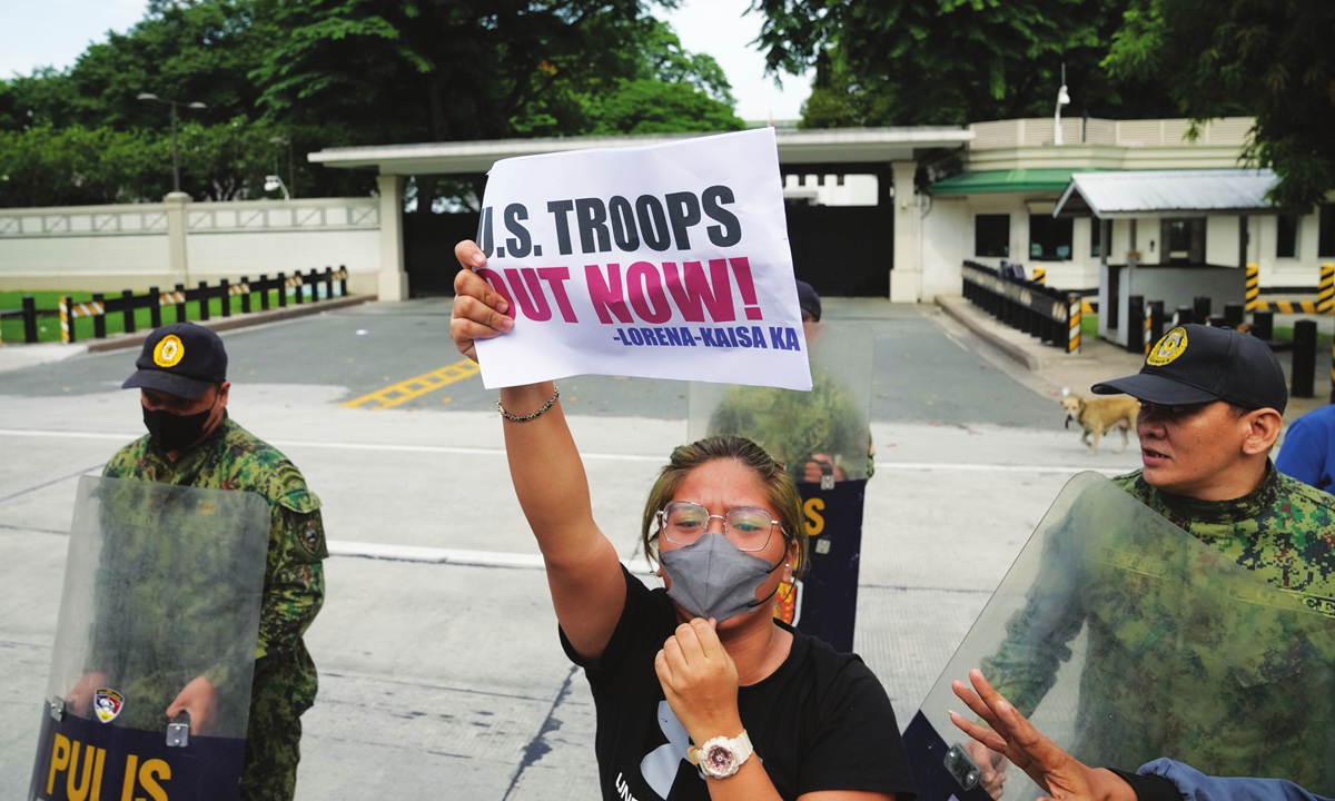 A protester holds a sign to protest against the continued presence of US troops in the Philippines in front of the US Embassy in Manila on July 4 2023. Photo: VCG