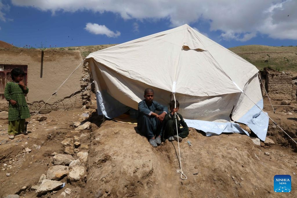 This photo taken on May 12, 2024 shows children sitting by a tent in Borka District, north Afghanistan's Baghlan Province. About 40,000 children have lost their homes in north Afghanistan's Baghlan province as heavy downpours and floods lashed the province and other regions on Friday, global charity Save the Children said Monday.(Photo: Xinhua)